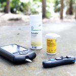 Un medidor de insulina y dos frascos con medicación para la diabetes